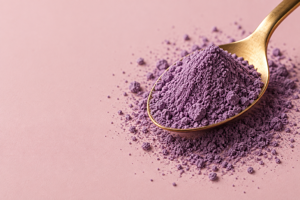 Fine lilac ube powder on a gold spoon